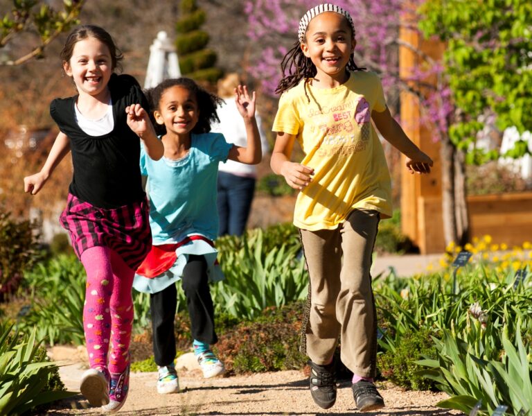 three girls running along a path in Denver Botanic Gardens during the spring